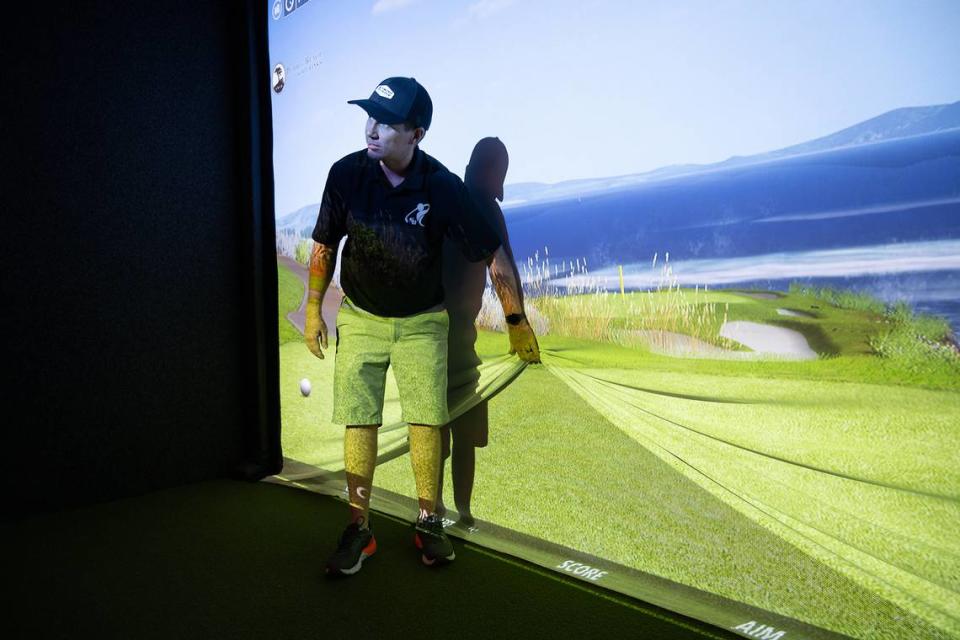 Owner Brian Harvey shows how the simulator screen can handle the impact of a golf ball at Swing Center Indoor Golf in Modesto, Calif., Wednesday, August 23, 2023.