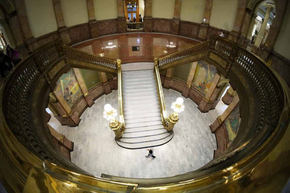 A lone person walks past the stairs in the rotunda of the State Capitol, Monday, May 8, 2023, in Denver. (AP Photo/David Zalubowski)