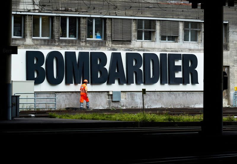 FILE PHOTO: A worker walks in front of a Bombardier advertising board at the SBB CFF Swiss railway train station in Bern