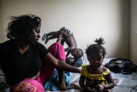 <p>Briana Shields (in the back),18, holds her little boy Fatdaddy (real name Bradford) in her bedroom in The Villa, a housing complex in North Flint. Briana’s cousin Coco and Coco’s little girl Lani are also pictured. Briana and Fatdaddy only lived there for about 6 months before they had to move back in with Briana’s mom. At the time this photo was taken, Fatdaddy’s father was in prison. (Photograph by Zackary Canepari) </p>