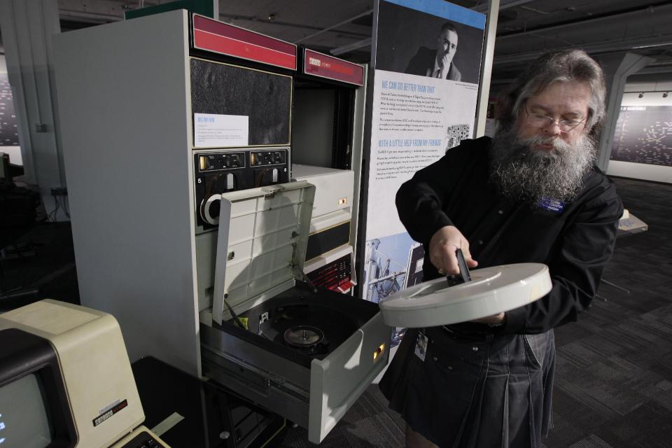 In this photo taken Oct. 30, 2012, Ian King, senior vintage systems engineer at the Living Computer Museum in Seattle, loads a large disk drive that holds 5mb of data into a working DEC 11/70 minicomputer from 1975. The machine is part of the collection of running computers at Paul Allen's newly opened Living Computer Museum. For tourists with an interest in Seattle's role as a high-tech hub, there hasn't been much here to see, other than driving over to Microsoft headquarters in suburban Redmond to take pictures of a bunch of boring buildings. But Microsoft co-founder Paul Allen has just opened the Living Computer Museum, with displays of old machines _ all in working order _ along with a geeky wish list of items he'd like to add, just in case anybody out there has an old tape drive or super-computer sitting around. (AP Photo/Ted S. Warren)