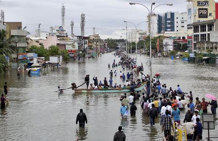 People travel on a boat as they move to safer places through a flooded road in Chennai, December 2, 2015. REUTERS/Stringer