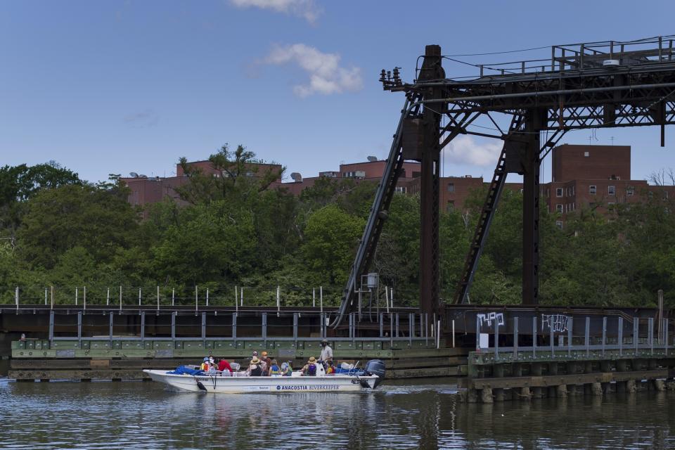 An Anacostia Riverkeeper boat passes along the river during a tour on Wednesday, May 1, 2024, at Anacostia Park in Washington. To help change long-held perceptions that the water is still as polluted as it once was, Anacostia Riverkeeper, an environmental nonprofit, has organized a swim event along a small stretch of the river designated safe for swimming. (AP Photo/Tom Brenner)