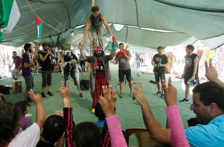 Clowns perform in front of Palestinian children in the Bedouin village of Khan al-Ahmar that Israel plans to demolish, in the occupied West Bank September 22, 2018. REUTERS/Mussa Qawasma