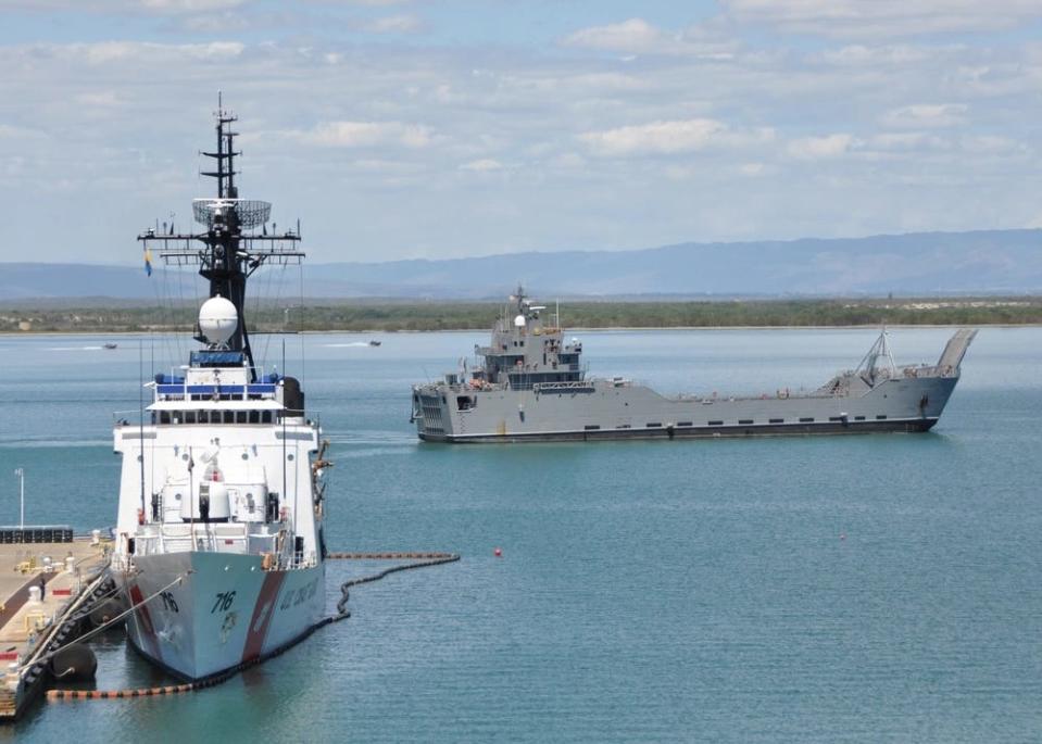 The US Army logistics support vessel General Frank S. Besson, Jr. passes the US Coast Guard cutter Dallas