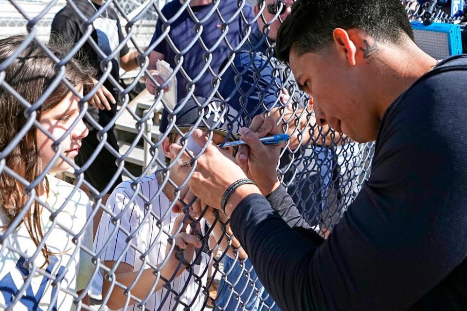 New York Yankees' Oswaldo Cabrera signs an autograph during a spring training baseball workout Monday, Feb. 20, 2023, in Tampa, Fla. (AP Photo/David J. Phillip)