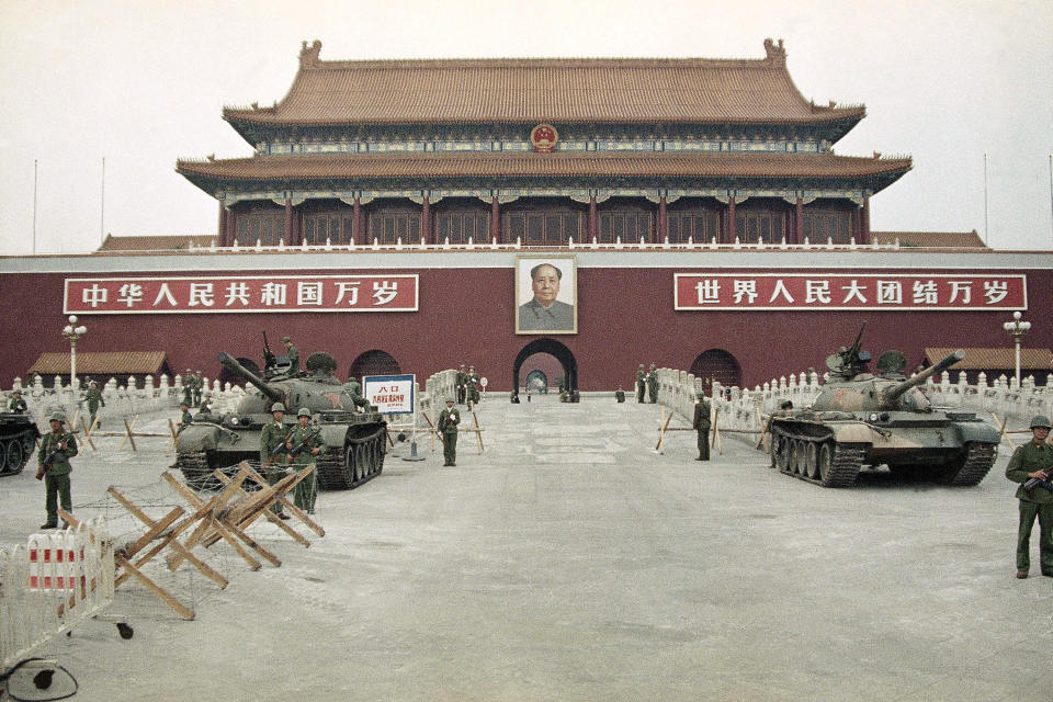 FILE - In this June 10, 1989 file photo, People's Liberation Army (PLA) troops stand guard with tanks in front of Tiananmen Square after crushing the students pro-democracy demonstrations in Beijing. Thirty years since the Tiananmen Square protests, China's economy has catapulted up the world rankings, yet political repression is harsher than ever. (AP Photo/Sadayuki Mikami, File)