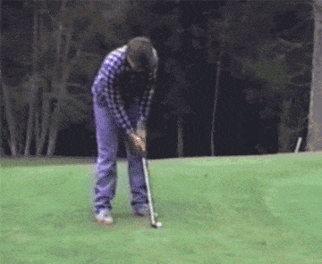 A golfer gets hit by a sprinkler that turns on mid-swing