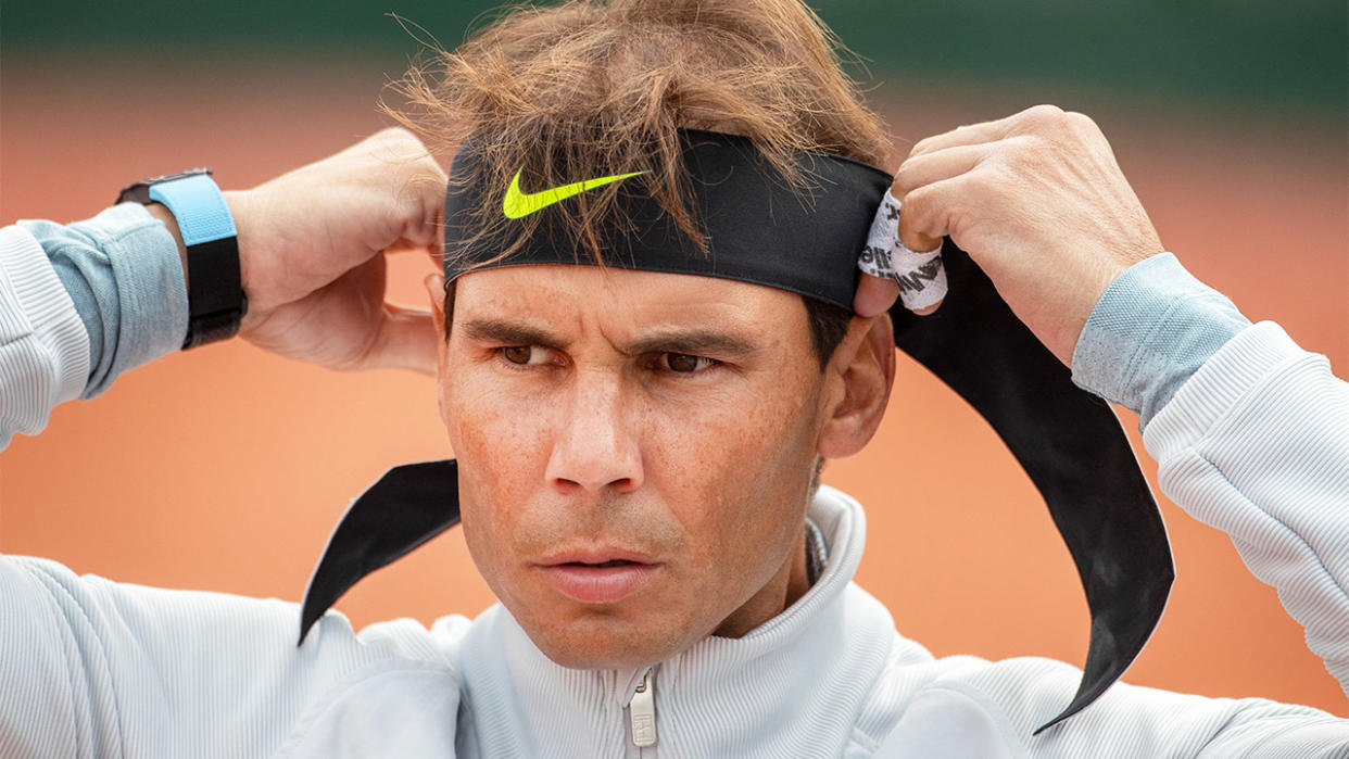 Rafa Nadal ties his headband ready for tennis training.