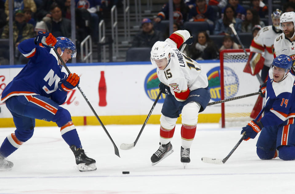 New York Islanders center Brock Nelson, left, and Florida Panthers center Anton Lundell (15) vie for the puck during the first period of an NHL hockey game Saturday, Jan. 27, 2024, in Elmont, N.Y. (AP Photo/John Munson)