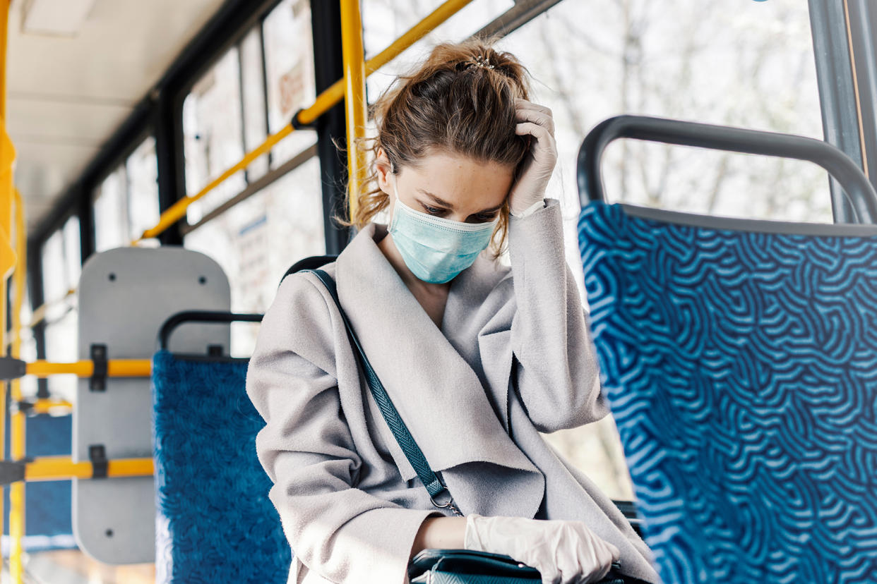 Woman wearing surgical protective mask having a headache in a pu - Credit: Seligaa/Adobe Stock