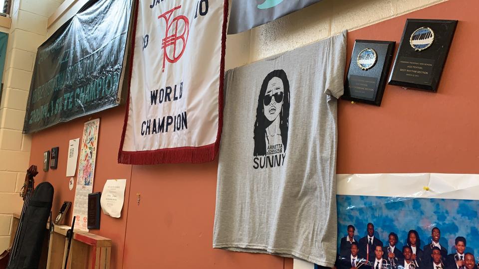 A t-shirt for Creative Arts Morgan Village Academy alumnus Arnetta Johnson's band Arnetta Johnson & Sunny hangs in the high school's band room where she spent countless hours rehearsing.