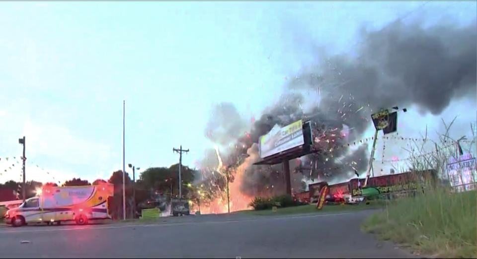 This still image taken from video provided by WCNC shows containers of fireworks exploding at the Davey Jones Fireworks and the House of Fireworks stores in Fort Mill, S.C., on Thursday, July 4, 2019. Firefighters had to dodge exploding rockets to douse a spectacular fire that destroyed containers of fireworks stored for sale on the Fourth of July. (WCNC via AP) MANDATORY CREDIT WCNC; CHARLOTTE, NC OUT .