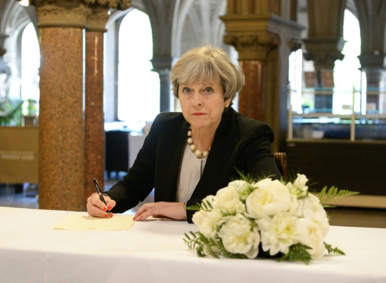Britain's Prime Minister Theresa May writes a message in a book of condolence at Manchester Town Hall May 23, 2017, following the terror attack at the Ariana Grande concert May 22