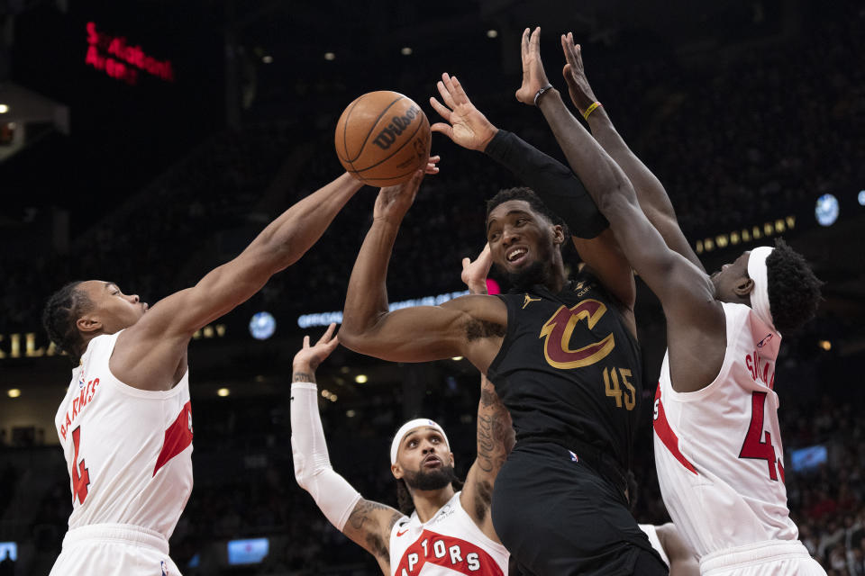 Cleveland Cavaliers' Donovan Mitchell (45) looks to lay off a pass after being boxed out by the Toronto Raptors defense during second-half NBA basketball game action in Toronto, Monday, Nov. 28, 2022. (Chris Young/The Canadian Press via AP)