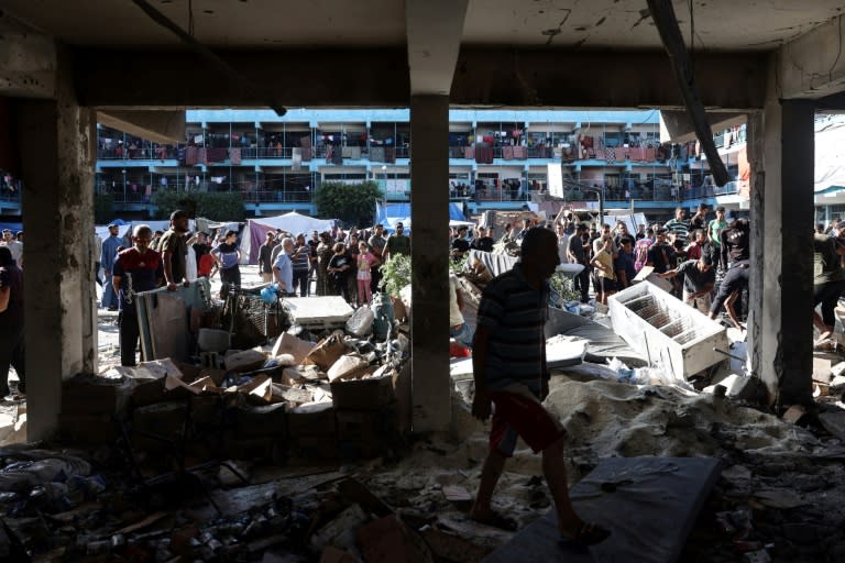 Palestinians inspect the damage at Al-Jawni School in central Gaza after an Israeli strike on the school turned shelter on Wednesday killed 18 people, including six UN staff (Eyad BABA)