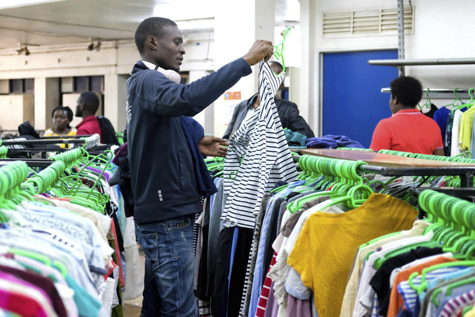 A man looks at second hand clothes at Green Shop, a chain specializing in used clothes, in Kampala, Uganda, Friday, Sept.15, 2023, Downtown Kampala’s Owino Market has long been a go-to enclave for rich and poor people alike looking for affordable but quality-made used clothes, underscoring perceptions that Western fashion is superior to what is made at home. But, despite their popularity, secondhand clothes are facing increasing pushback. (AP Photo/Hajarah Nalwadda)