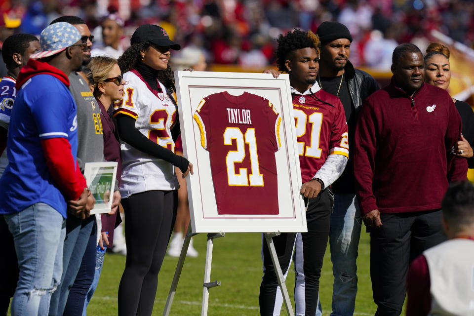 Family members of the late Sean Taylor gather on the field as the Washington Football Team retire his jersey during a halftime ceremony at an NFL football game against the Kansas City Chiefs, Sunday, Oct. 17, 2021, in Landover, Md. (AP Photo/Patrick Semansky)