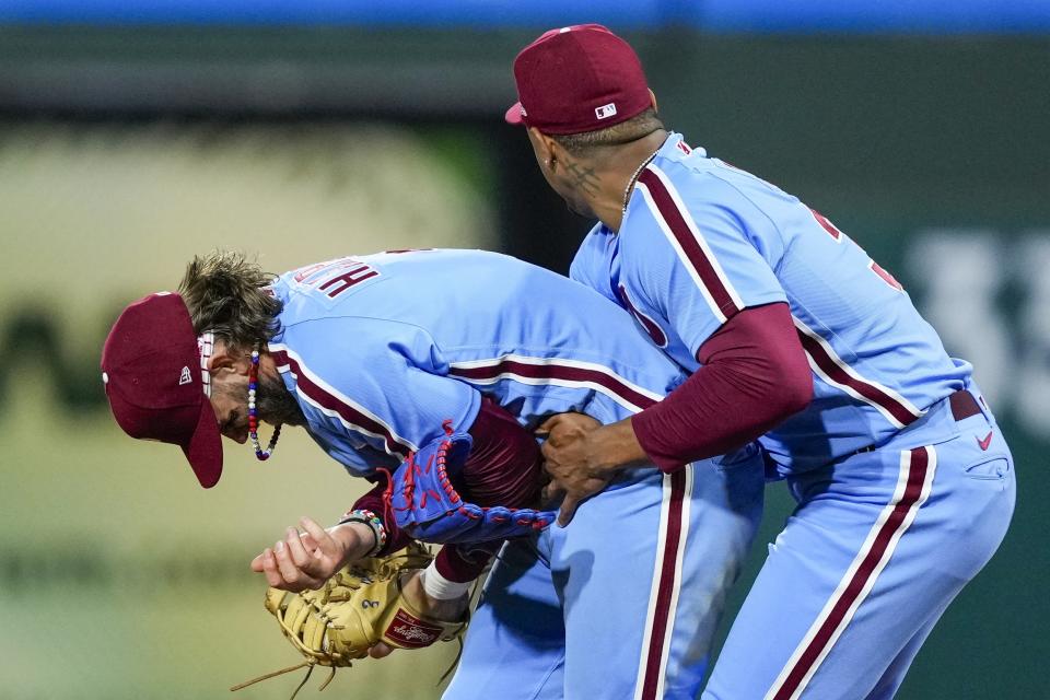 Philadelphia Phillies' Gregory Soto holds Bryce Harper, who hurt his arm during the eighth inning of Game 4 of a baseball NL Division Series against the Atlanta Braves Thursday, Oct. 12, 2023, in Philadelphia. (AP Photo/Matt Rourke)