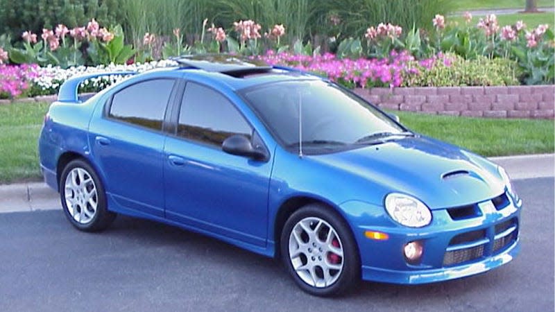 A photo of a blue Dodge Neon with a rear wing. 