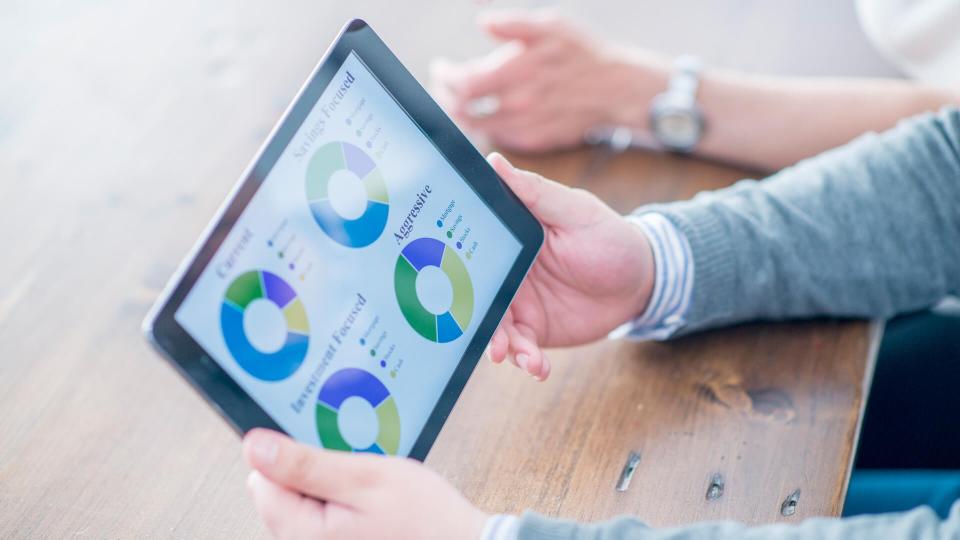 A businessman is looking at a chart of the companies portfolio on a digital tablet.