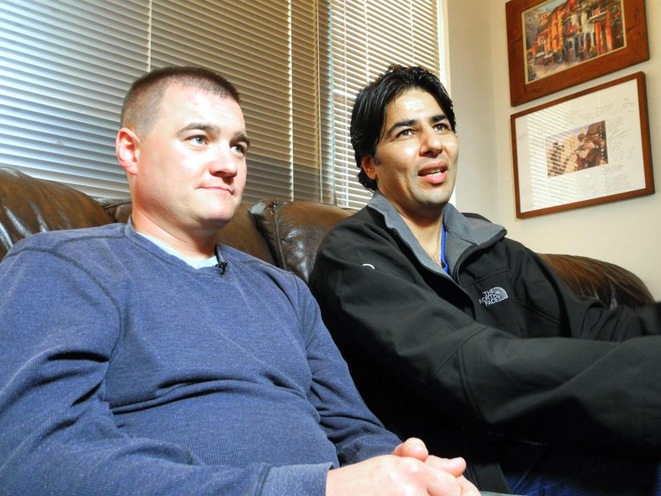 US Army Captain Matt Zeller (L) with translator Janis Shenwari, whom he credits for saving his life in a firefight in Afghanistan in November 2008, during an interview on November 21, 2013 in Arlington, Virginia. After 5 years of struggle, Shenwari is one of the lucky few who was able to take advantage of the special Visa program for Afghanistan interpreters.