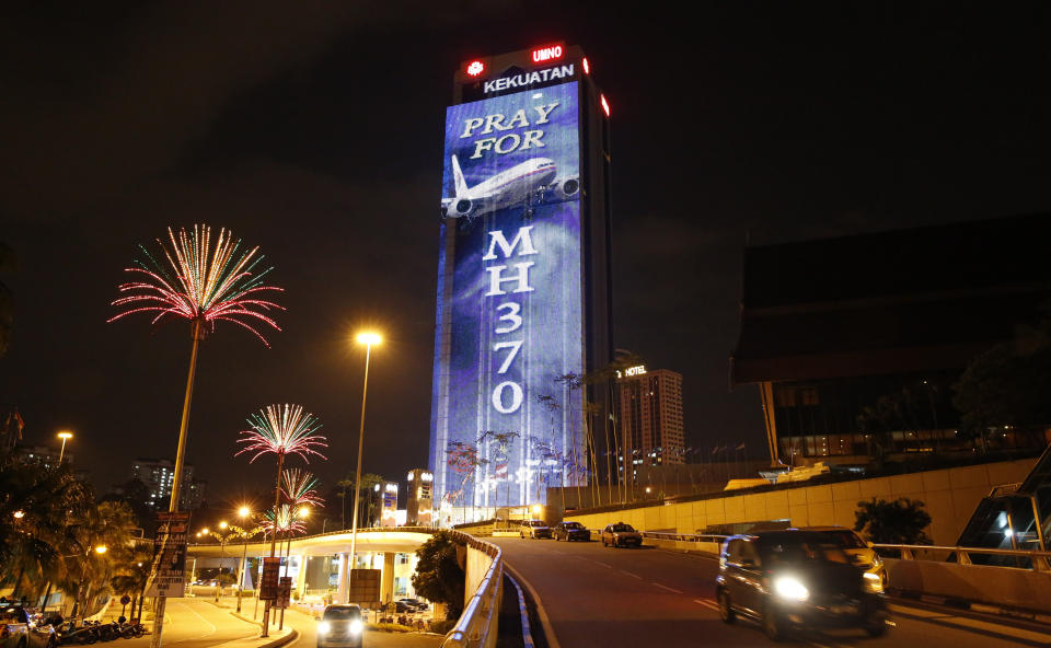 FILE - An office building is illuminated with lights displaying "Pray for MH370" in Kuala Lumpur, Malaysia, March 24, 2014. A decade ago this week, a Malaysia Airlines flight vanished without a trace to become one of aviation’s biggest mystery. Investigators still do not know exactly what happened to the plane and its 239 passengers. (AP Photo/Vincent Thian, File)