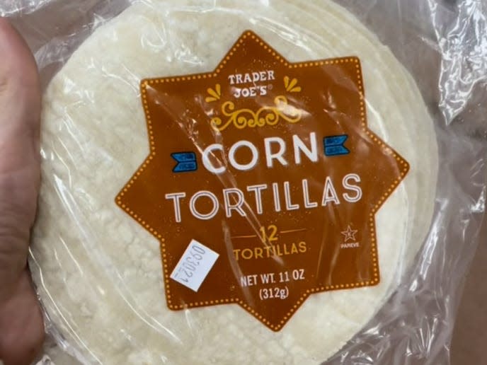 hand holding package of trader joe's corn tortillas