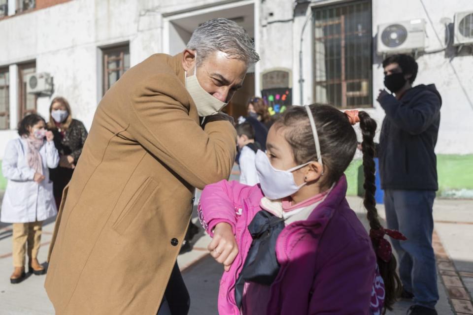 <div class="inline-image__caption"><p>A school official greets a student during the first day of the final phase of reopening schools in Montevideo, Uruguay. </p></div> <div class="inline-image__credit">Ernesto Ryan/Getty</div>