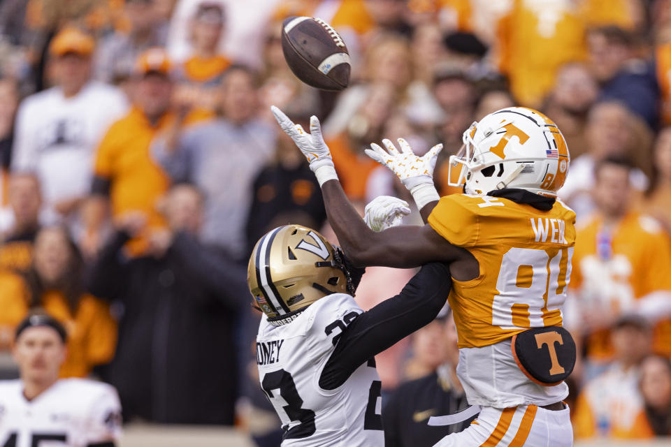 Tennessee wide receiver Kaleb Webb (84) goes for a catch as he's defended by Vanderbilt defensive back Jaylen Mahoney (23) during the first half of an NCAA college football game Saturday, Nov. 25, 2023, in Knoxville, Tenn. (AP Photo/Wade Payne)