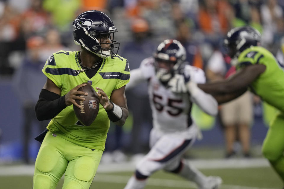 Seattle Seahawks quarterback Geno Smith, left, drops to pass against the Denver Broncos during the second half of an NFL football game, Monday, Sept. 12, 2022, in Seattle. The Seahawks won 17-16. (AP Photo/Stephen Brashear)