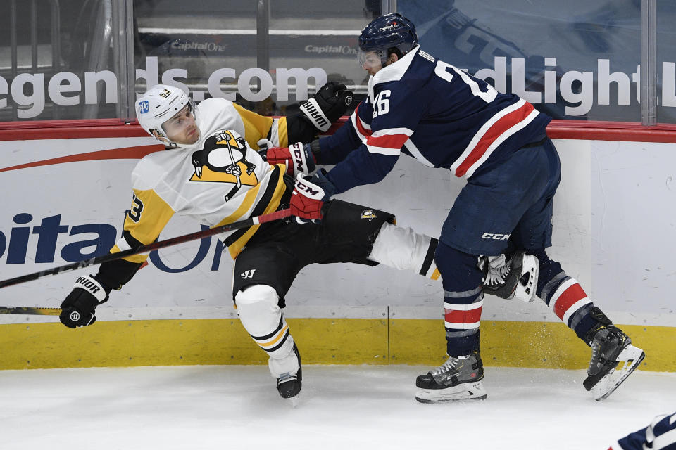 Washington Capitals center Nic Dowd (26) checks Pittsburgh Penguins center Teddy Blueger (53) during the first period of an NHL hockey game Saturday, May 1, 2021, in Washington. (AP Photo/Nick Wass)