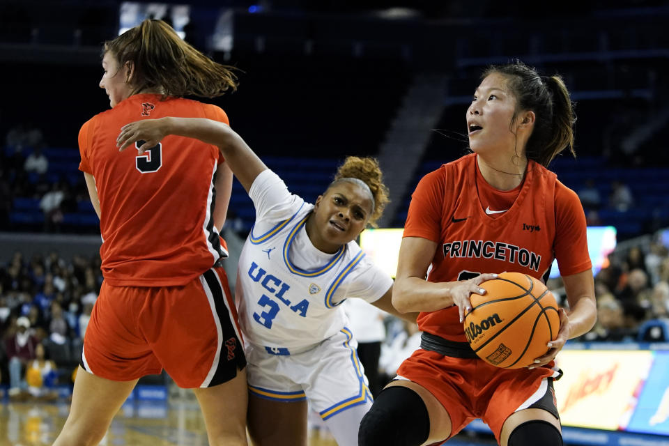 Princeton guard Kaitlyn Chen, right,prepares to shoot as UCLA guard Londynn Jones, center, attempts to run past Princeton forward Paige Morton, left, during the first half of an NCAA college basketball game, Friday, Nov. 17, 2023, in Los Angeles. (AP Photo/Ryan Sun)