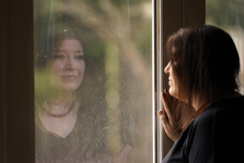 Keri Wegg is reflected in a sliding glass door as she looks outside her home in Westfield, Ind., on Monday, March 22, 2021. The Indiana nurse came down with COVID-19 in the summer of 2020; her condition spiraled downward, and her life was saved only by grace of a double lung transplant. The road to normal is a long one, but she's bolstered by the love and support of her husband and sons, and by her own indomitable spirit. (AP Photo/Charles Rex Arbogast)