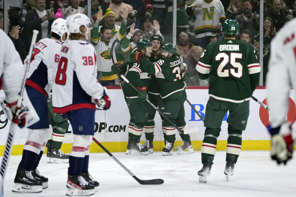 Minnesota Wild defenseman Brock Faber, center, celebrates with teammates after scoring during the first period of an NHL hockey game against the Washington Capitals, Tuesday, Jan. 23, 2024, in St. Paul, Minn. (AP Photo/Abbie Parr)