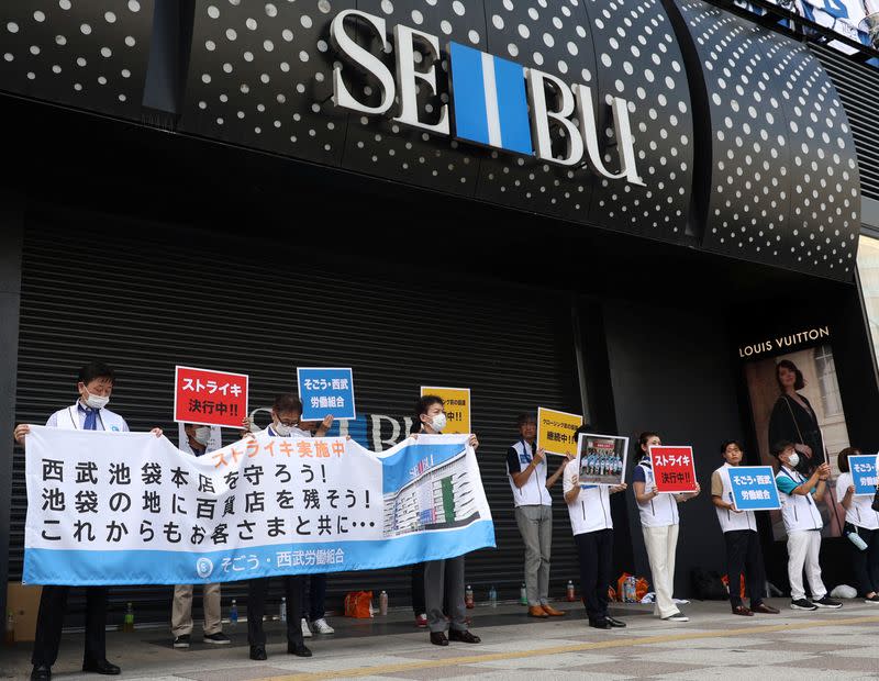 Union workers of Sogo & Seibu hold banners which read 'on strike' in front of the company's flagship Seibu Ikebukuro store in Tokyo