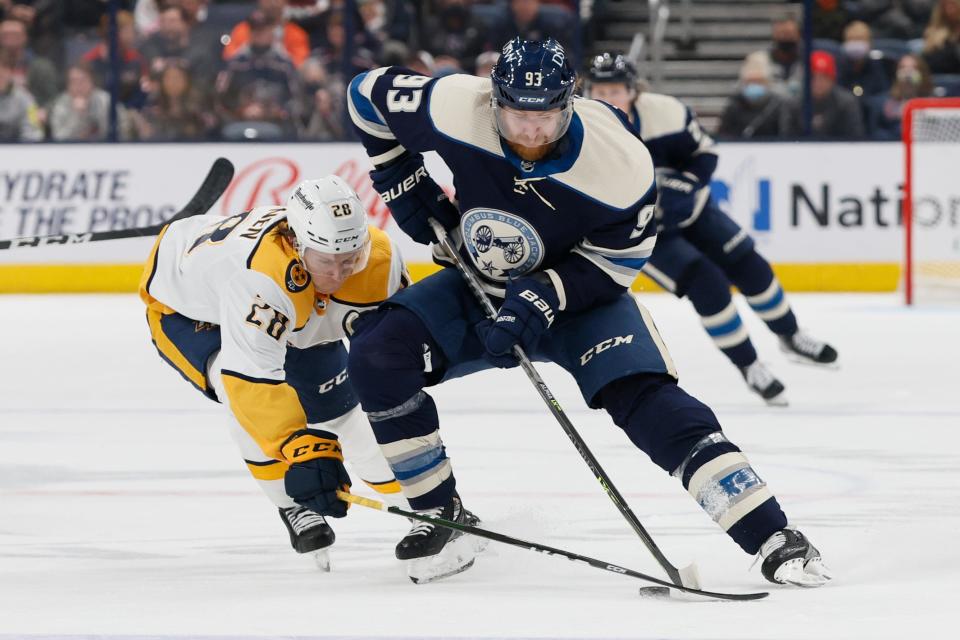 Nashville Predators' Eeli Tolvanen, left, tries to knock the puck away from Columbus Blue Jackets' Jakub Voracek during the second period of an NHL hockey game Thursday, Dec. 30, 2021, in Columbus, Ohio. (AP Photo/Jay LaPrete)