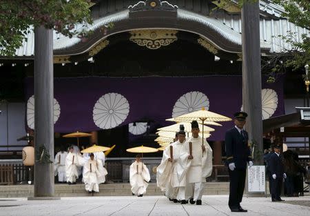 Shinto priests holding traditional umbrellas leave from the main shrine after a ritual to cleanse themselves during annual Spring Festival at the Yasukuni Shrine in Tokyo, Japan, April 21, 2016. REUTERS/Issei Kato