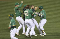 Oakland Athletics's Ramón Laureano celebrates with teammates after his single drove in the winning run against the Houston Astros during the ninth inning of a baseball game in Oakland, Calif., Wednesday, Sept. 9, 2020. (AP Photo/Jed Jacobsohn)