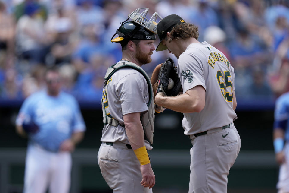 Oakland Athletics catcher Kyle McCann, left, and relief pitcher Tyler Ferguson (65) meet on the mound during the sixth inning of a baseball game against the Kansas City Royals Sunday, May 19, 2024, in Kansas City, Mo. (AP Photo/Charlie Riedel)