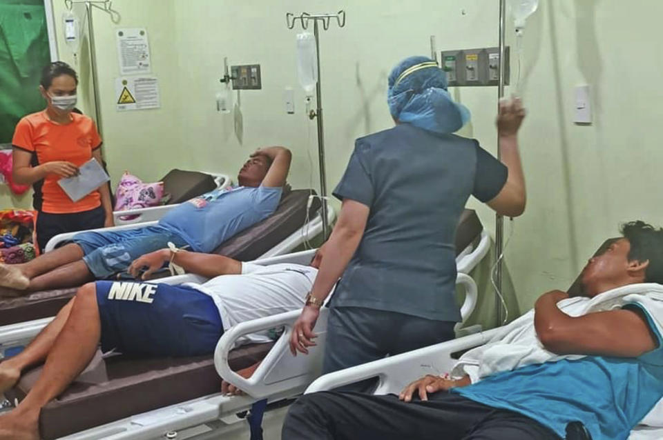 In this photo provided by the Philippine Coast Guard, crew members of the cargo vessel LCT Cebu Great Ocean are treated at a hospital on Wednesday, April 21, 2021, after their ship ran aground in Surigao del Norte, Southern Philippines. Rescuers in the southern Philippines found the bodies of four crew members Wednesday and rescued seven others who jumped off a cargo vessel, which took in water and listed after its anchor broke in rough seas, officials said. (Philippine Coast Guard via AP)