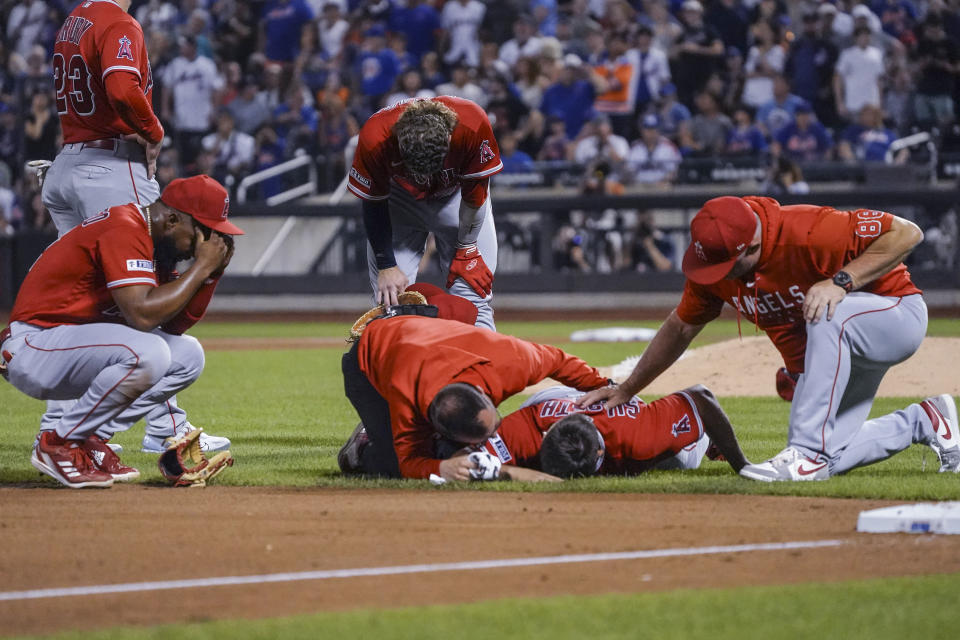 Los Angeles Angels starting pitcher Chase Silset, second from right, lies on the field after being struck by a thrown ball during the fourth inning of the team's baseball game against the New York Mets, Saturday, Aug. 26, 2023, in New York. (AP Photo/Bebeto Matthews)