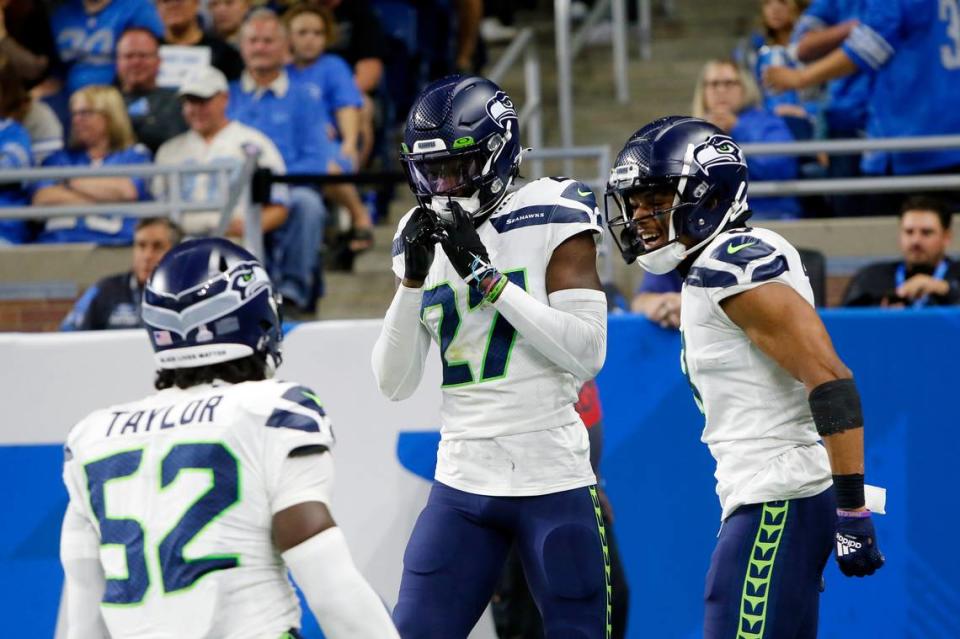 Seattle Seahawks cornerback Tariq Woolen celebrates his interception return for a touchdown during the second half of an NFL football game against the Detroit Lions, Sunday, Oct. 2, 2022, in Detroit. (AP Photo/Duane Burleson)