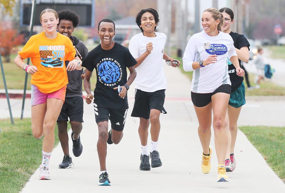 Perry High School junior cross country runner Yonas Andemichael runs with his state qualifier teammates during a team practice on Oct. 25 in Perry.