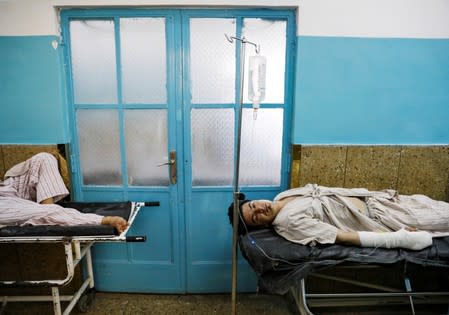 Injured men receive treatment in the hospital after sustaining wounds from a blast at a wedding hall in Kabul, Afghanistan