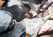 In this photo provided by the government's Search and Rescue agency AFAD, rescue workers, who were trying to reach survivors in the rubble of a collapsed building, surround Ayda Gezgin in the Turkish coastal city of Izmir, Turkey, Tuesday, Nov. 3, 2020, as they pull the young girl out alive from the rubble of a collapsed apartment building four days after a strong earthquake hit Turkey and Greece. The girl, Ayda Gezgin, was seen being taken into an ambulance on Tuesday, wrapped in a thermal blanket, amid the sound of cheers and applause from rescue workers. (AFAD via AP)