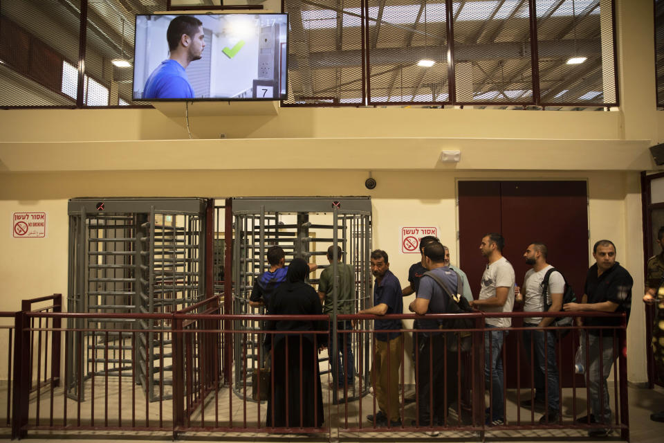 In this Thursday, July 11, 2019 photo, Palestinians wait to enter Israel at the Qalandia crossing in Jerusalem. Israel’s military has invested tens of millions of dollars to upgrade West Bank crossings and ease entry for Palestinian workers. But while the upgrades may have eased crossing for Palestinians entering Israeli daily for work, critics say they are a sign of the ossification of Israel’s 52-year occupation of the West Bank and slam the military’s use of facial recognition technology as problematic. (AP Photo/Sebastian Scheiner)