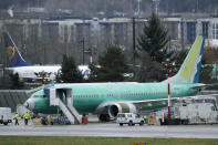 Workers walk near a Boeing 737 Max airplane being built for Oman Air, Wednesday, Dec. 11, 2019, at Renton Municipal Airport in Renton, Wash. The chairman of the House Transportation Committee said Wednesday that an FAA analysis of the 737 Max performed after a fatal crash in 2018 predicted "as many as 15 future fatal crashes within the life of the fleet." (AP Photo/Ted S. Warren)
