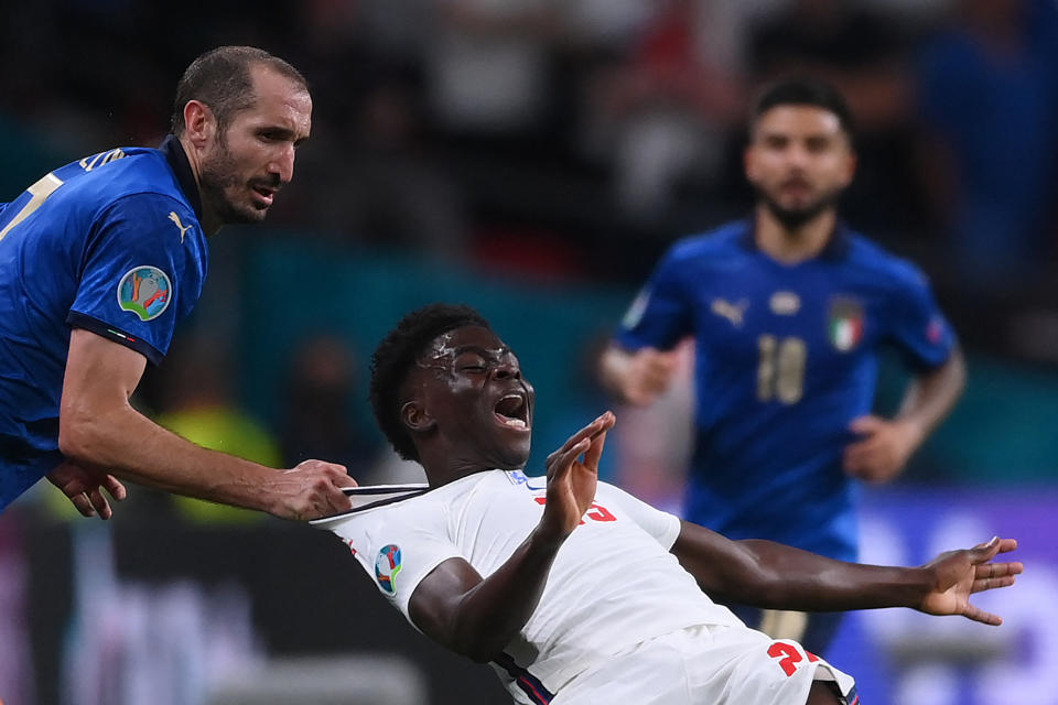TOPSHOT - Italy's defender Giorgio Chiellini (L) fouls England's midfielder Bukayo Saka during the UEFA EURO 2020 final football match between Italy and England at the Wembley Stadium in London on July 11, 2021. (Photo by Laurence Griffiths / POOL / AFP) (Photo by LAURENCE GRIFFITHS/POOL/AFP via Getty Images)