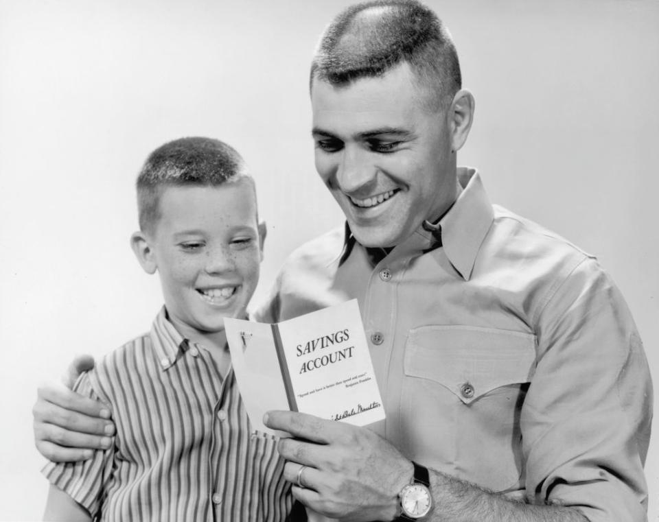 dad and son looking at a bankbook